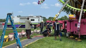 A professional crew sets up a ride at the Delaware County Fairgrounds. Fifty years ago at another amusement park, a remarkable foreman coached some amateurs through the job. Photo by Nancy Carlson.