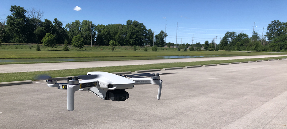 Close up photo of a drone hovering 3 feet above ground. Photo by Mike Rhodes