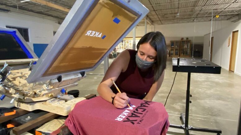 A participant in the Maker Mondays screen printing workshop is adding final touches to her t-shirt design. Photo by: Kyra Zylstra