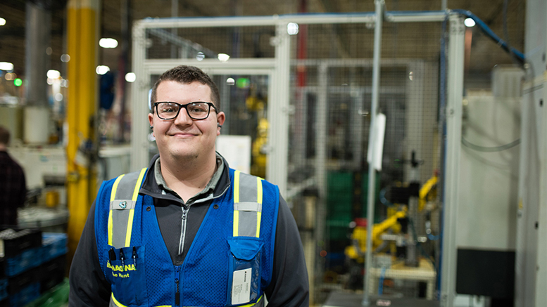 Magna Powertrain manufacturing engineer Abe Hunt stands in front of equipment at his workplace. Hunt is a graduate of Purdue Polytechnic Anderson. Photo by Arin Anderson.