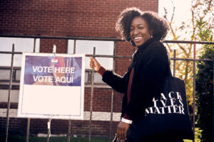A woman is pictured standing in line to vote. Photo by storyblocks