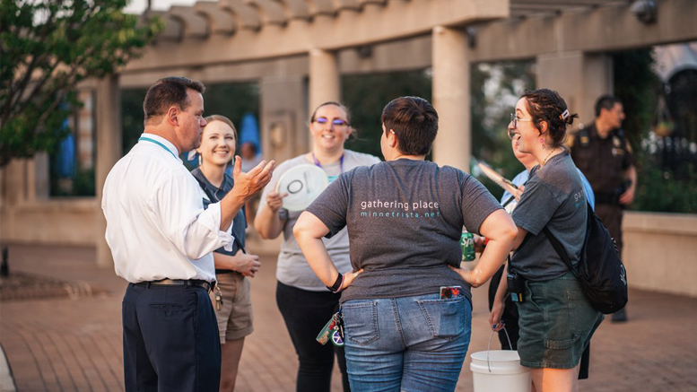 Brian is pictured on the far left as he speaks to a group. Photo provided