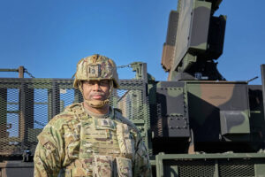 U.S. Army Command Sgt. Maj. Robinson, the Command Sgt. Maj. of 52d Air Defense Artillery Brigade, poses in front of a Sentinel Radar during Exercise Southern Shield in Romania, Nov. 15, 2024. The event highlights NATO's defensive readiness and air defense interoperability among Allied forces. U.S. Army photo by Capt. Leara Shumate.