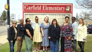 YWCA Central Indiana Board members, Capital Campaign Cabinet members and staff celebrate under the “Garfield Elementary” sign. Photo provided,