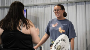 Sarah Russell, owner of Grace & Co. Coffee and a MadJax Maker Space member, talks with a customer during a market event at MadJax Maker Force in downtown Muncie. Small Business Week supports entrepreneurs like Sarah by providing access to business education, resources, and community connections. Photo provided.