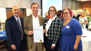 At a recent public event, Muncie Mayor Dan Ridenour (second from left) presented a National Library Week Proclamation to MPL Library Director Alan Kornblau, MPL Board of Trustees President Traci Lutton, and MPL Assistant Director Katherine Mitchell. Photo by Susan Fisher.
