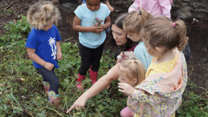 An educator leads children in outdoor exploration at a local early learning program. Photo provided.